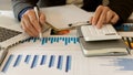 Businessman studying statistics and analyzing pens and graphing documents on a desk with a laptop and a calculator Royalty Free Stock Photo