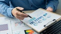 Businessman studying statistics and analyzing pens and graphing documents on a desk with a laptop and a calculator Royalty Free Stock Photo