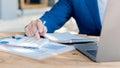 Businessman studying statistics and analyzing pens and graphing documents on a desk with a laptop and a calculator Royalty Free Stock Photo