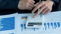 Businessman studying statistics and analyzing pens and graphing documents on a desk with a laptop and a calculator Royalty Free Stock Photo