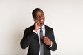 Black male satisfied manager in suit standing talking on phone. Portrait