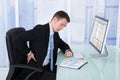 Businessman suffering from backache at computer desk Royalty Free Stock Photo