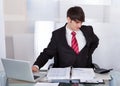 Businessman suffering from backache at desk Royalty Free Stock Photo