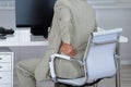 Businessman Suffering From Backache While Sitting On Chair Royalty Free Stock Photo