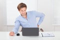 Businessman suffering from backache while working on laptop Royalty Free Stock Photo