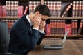 Businessman Suffering From Headache While Using Laptop
