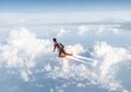 Businessman in suit and aviator hat flying in sky