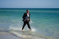 Businessman suit barefoot running on beach. Handsome business man on summer vacation. Businessman running on sea holding Royalty Free Stock Photo