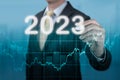 Businessman in suit forecast analysis plan profit chart. economic forecasts for 2023. businessman writes 2023 on virtual screen.