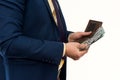 Businessman in suit gets us money from the wallet, isolated. Male hands holding a black leather wallet with US Dollars cash inside Royalty Free Stock Photo