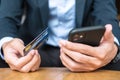 Businessman in suit holding credit card and using touchscreen smartphone for online shopping while making orders in the cafe or Royalty Free Stock Photo