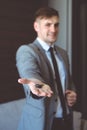 Businessman in suit holding house key in hand. Mortgage, credit or property concept Royalty Free Stock Photo