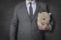 Businessman in a suit holding a teddy bear