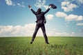 Businessman in suit jumping in field