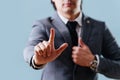 Businessman in suit making objection gesture , holding index finger up over blue Royalty Free Stock Photo