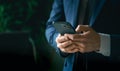 Businessman in suit with mobile phone in hands. Man typing message, using social net. Checking news. Making business Royalty Free Stock Photo