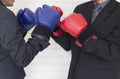 businessman in suit with red and blue boxing gloves punching each other Royalty Free Stock Photo