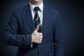 Businessman in suit showing Good sign with his thumb up on blue background Royalty Free Stock Photo