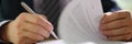 Businessman in suit signing and officially certificating important document closeup