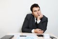 Businessman in suit sits at table with notebook, documents