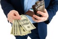 Businessman in suit takes out dollar from wallet, hand holding cash, closeup.