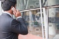 businessman in suit talking on smart phone while standing outside building. young asian male using cellphone for work at modern o Royalty Free Stock Photo