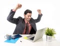 businessman in suit and tie working at office computer desk doing victory sign with his arms happy and excited Royalty Free Stock Photo