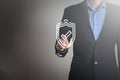 Businessman in a suit touching screen shield with a tick protection conncept selecting a futuristic padlock with a data center.