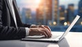 a businessman in a suit typing on a laptop, corporate sunset cityscape views in the background