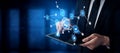 Businessman in suit using tablet with digital network graphics, graphs, connections representing technology and Royalty Free Stock Photo