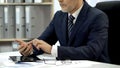 Businessman in suit working in office dialing phone, using financial application Royalty Free Stock Photo