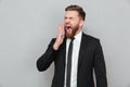 Businessman in suit yawning and covering his mouth with hand Royalty Free Stock Photo