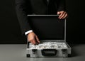 Businessman with suitcase full of money Royalty Free Stock Photo