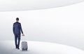 Businessman with suitcase walking in waiting room Royalty Free Stock Photo