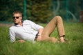 Businessman in sunglasses on sunny outdoor. Man relax on green grass. Handsome macho enjoy summer day. Fashion style and Royalty Free Stock Photo