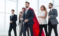 businessman in Superman cloak and business team standing in office lobby