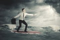 Businessman surfing on a cloudy day