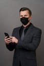 Businessman with surgical medical mask using mobile phone Royalty Free Stock Photo