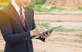 Businessman surveying land for industrial project.Selective focus at hand