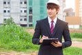 Businessman surveying land for industrial project.Selective focus at hand