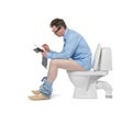 Businessman with tablet pc sitting on the toilet. Isolated on white background. Always at work concept