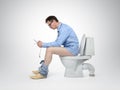 Businessman with tablet pc sitting on the toilet