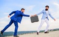 Businessman takes away briefcase from business partner. Fraud and extortion concept. Men suits handover briefcase Royalty Free Stock Photo