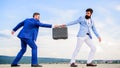 Businessman takes away briefcase from business partner. Men suits handover briefcase. Rascal racketeer extortionist Royalty Free Stock Photo