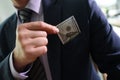 Businessman takes dollar banknote out of suit chest pocket