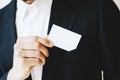 Businessman takes out a blank white business card from his jacket pocket.Horizontal mockup, blurred background. Royalty Free Stock Photo