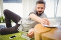 Businessman taking coffee cup while relaxing at creative office Royalty Free Stock Photo