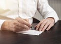 Businessman taking memo note closeup at desk and writing reminder on paper sheet Royalty Free Stock Photo