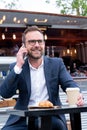 Mature Businessman Taking Phone Call On Mobile Sitting At Outdoor Coffee Shop Royalty Free Stock Photo