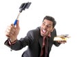 businessman taking selfie photo with mobile phone camera and stick posing happy and successful with gold bar and money Royalty Free Stock Photo